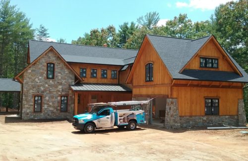 a garage door specialists inc truck parked in front of a house receiving a new garage door in Rutherfordton North Carolina