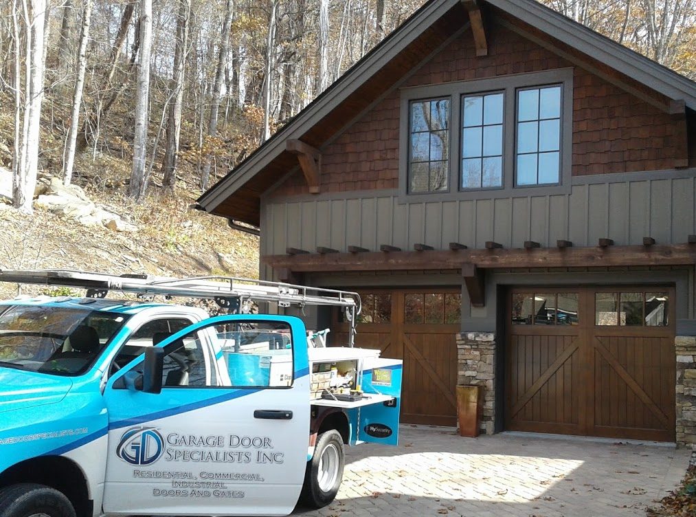 a garage door specialists truck parked next to a garage door in Lenior