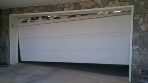 a broken garage door about to be fixed by emergency garage door services